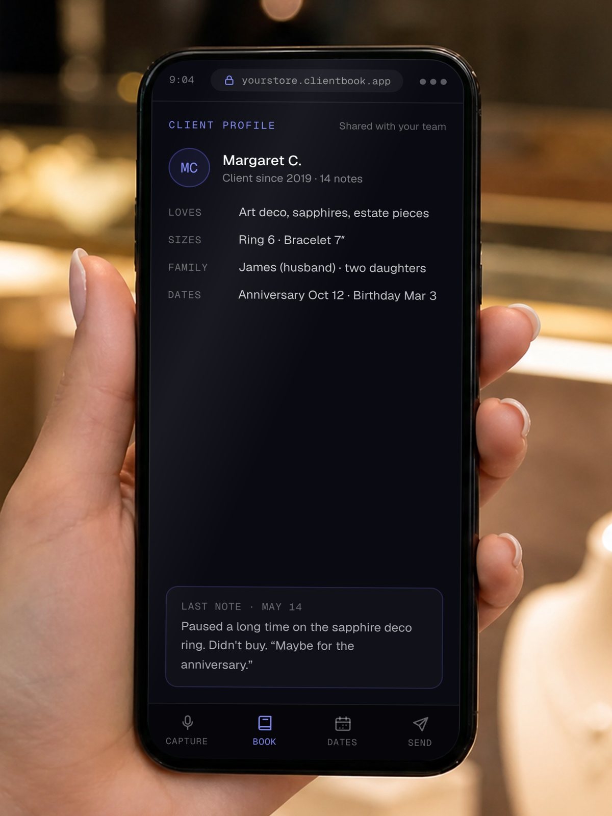 The Client Book open on a phone at a jewelry counter, showing a client profile